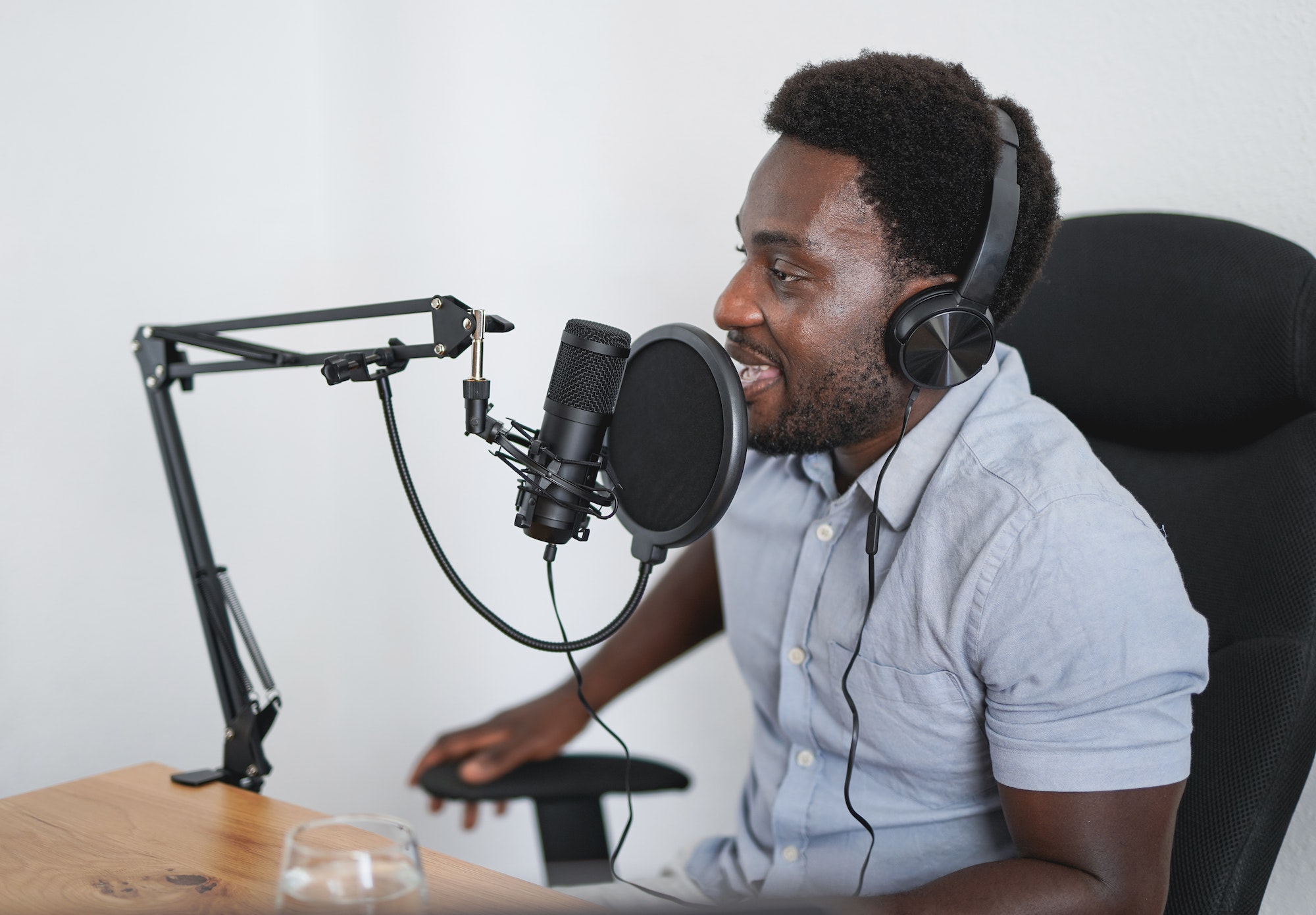 Young african man recording a podcast inside studio